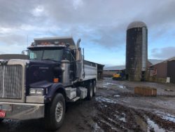 Dump truck parked by silo